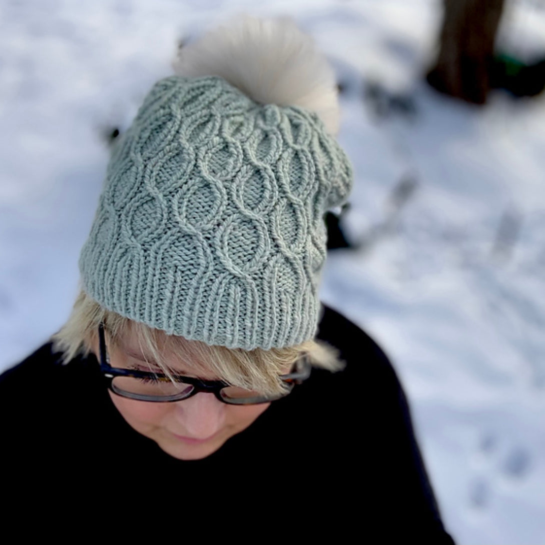 woman wearing hand knit hat with pom pom