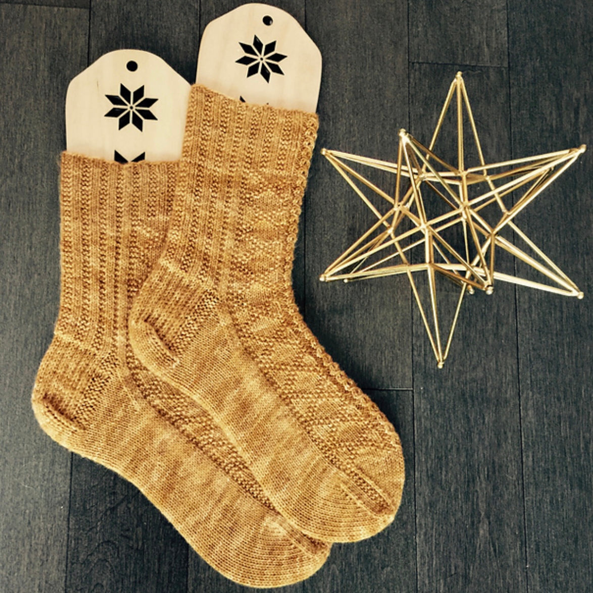 hand knit socks displayed of sock blockers with decorative star 
