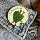 enamel pin of a yarn heart with needles