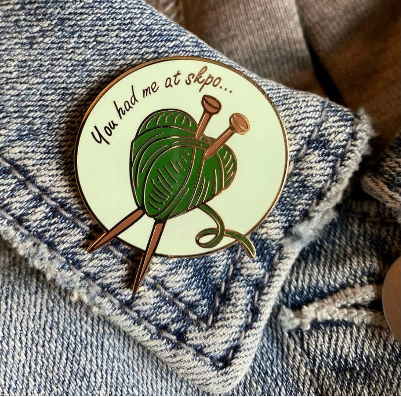 enamel pin of a yarn heart with needles