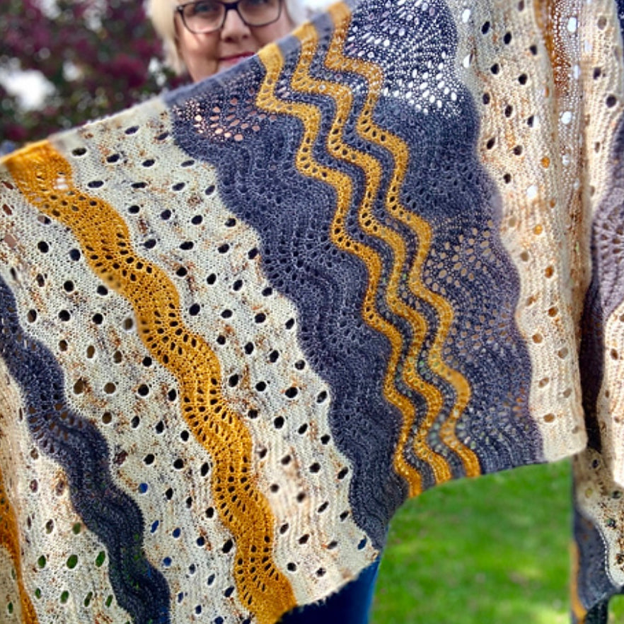 woman holding a hand knit shawl