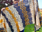 woman holding a hand knit shawl