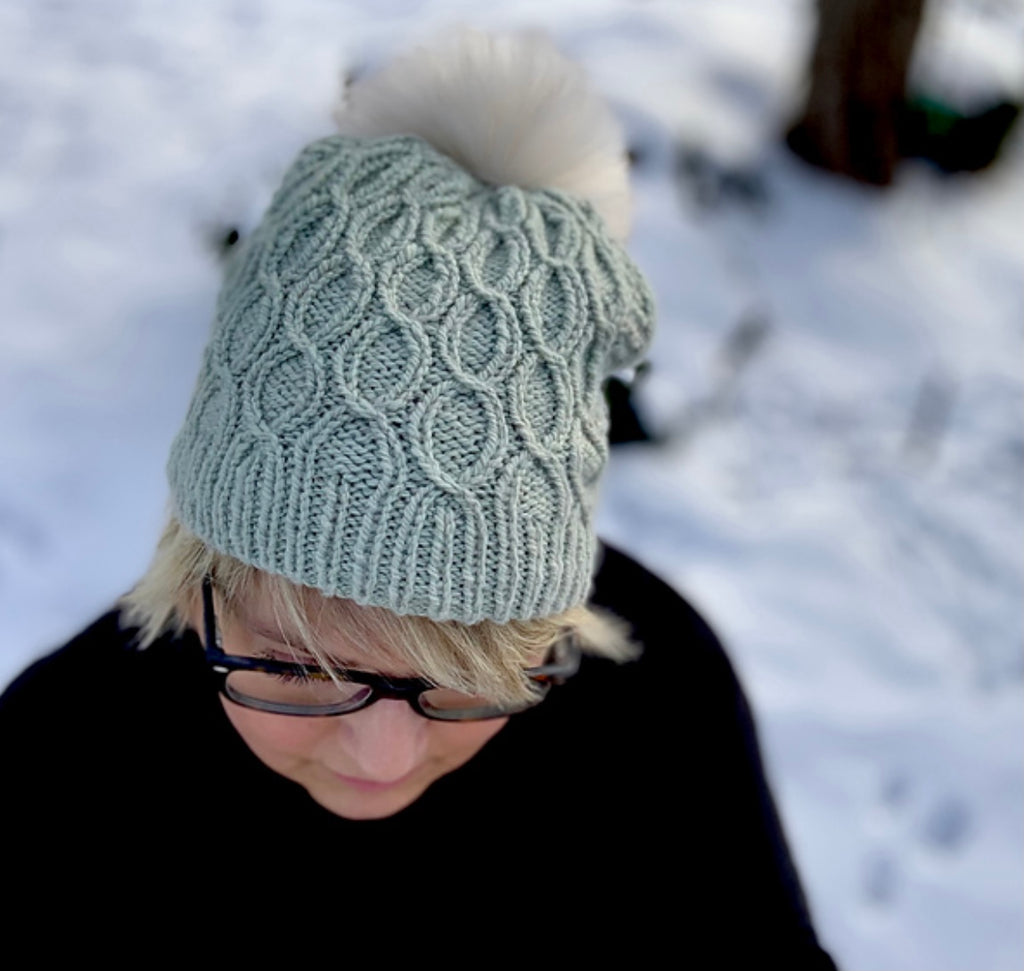 woman wearing hand knit hat with pom pom