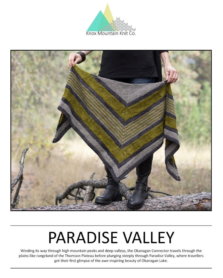 woman standing in nature holding hand knit shawl