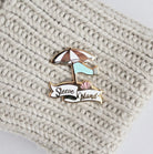 enamel pin of an umbrella and knit scarf